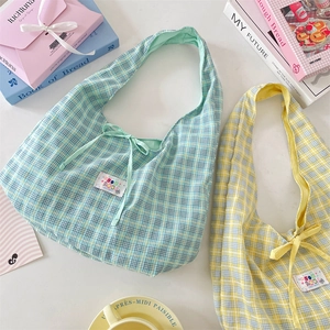 Detailed macro shot of lightweight plaid canvas vest bags in mint green and soft yellow