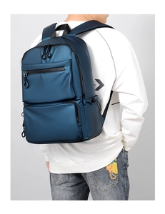 Vista laterale dello zaino blu navy con tasche anteriori e finitura opaca