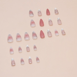 Pink blush press-on nails with bow designs and white French tips in almond shape