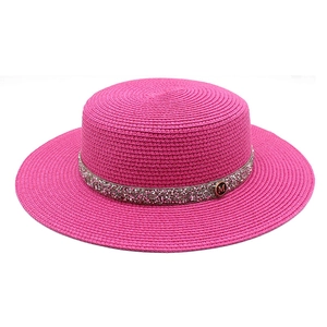 Detail of fuchsia straw hat with rhinestone band and metal M logo for women