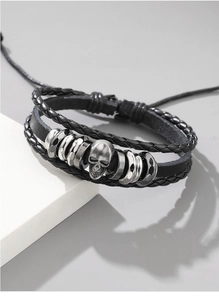 Detailed view of layered black woven leather bracelet with vintage silver skull bead