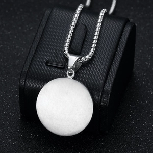 Collier hip hop argenté minimaliste avec pendentif rond sur un coffret à bijoux noir