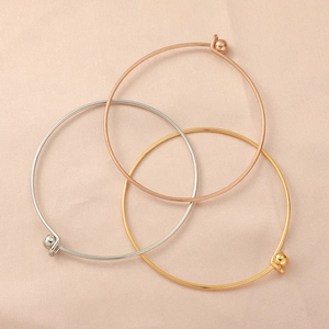 Minimalist 60mm stainless steel bangles in gold, rose gold and silver on velvet background