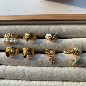 Sélection de bagues en acier inoxydable avec finition dorée, perles et breloques étoile
