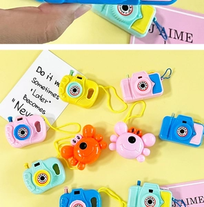 Detailansicht bunter Mini-Spielzeugkameras und Krabbenfiguren auf gelbem Hintergrund
