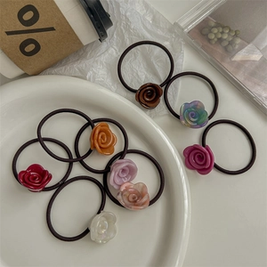 Elegant rose floral hair ties in various colors displayed on a decorative white tray