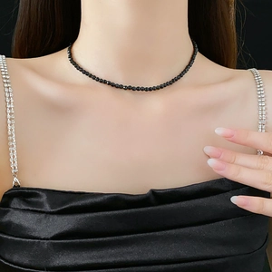 Detail of minimalist faceted black crystal beaded necklace on female model neck