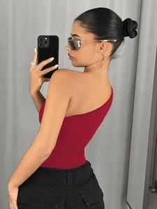 Vista lateral del body rojo de un hombro combinado con pantalones negros para una silueta
