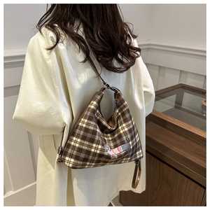 Detail of checkered shoulder bag featuring vintage brown pattern and dog embroidery