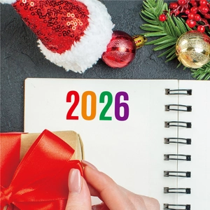 Top view of a 2026 planner with spiral binding surrounded by Christmas decorations