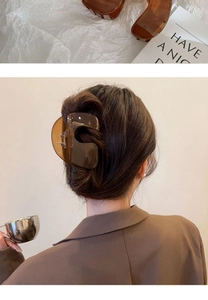 Detail showing amber translucent shark hair claw clip as a flat lay and on model's hair