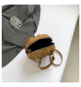 Detail of floral embossed leather shell bag with silver zipper and slim strap