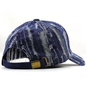 Detail of vintage washed denim baseball cap with distressed texture and brass buckle