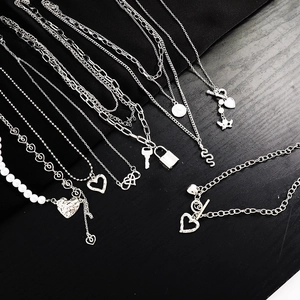 Detailed collection of silver heart and pearl charms on mixed metal chains and bracelets