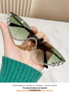 Close-up of cat-eye sunglasses with green gradient lenses and crystal embellishments