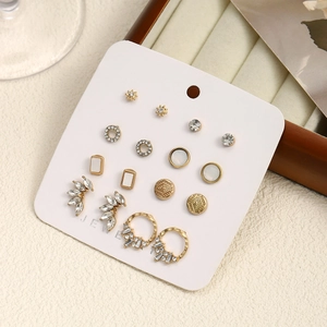 Detail of assorted gold-tone earring set with pearls and crystals on jewelry card