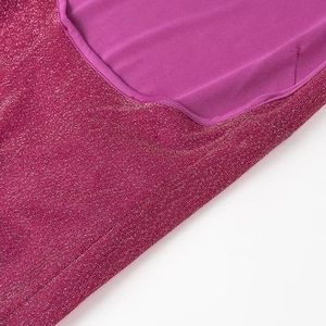 Detailed view of magenta sequin fabric combined with purple lining for a party dress