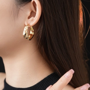 Minimalist gold pleated C-shape hoop earrings with irregular hammered liquid metal texture