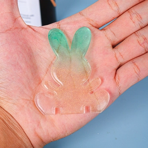Detail of gradient rabbit resin craft with gold glitter showing phone stand slots