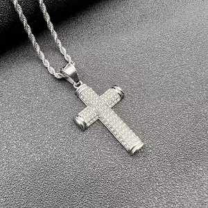 Detailed close-up of a silver cross pendant with sparkling crystals on a twist chain