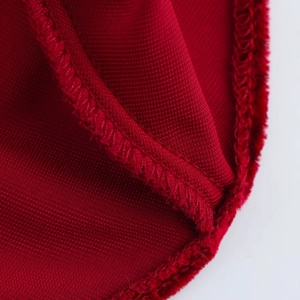 Gros plan du tissu satiné rouge foncé montrant la couture de qualité et la texture