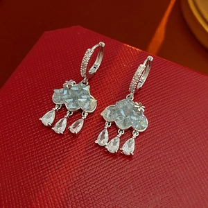 Détail de boucles d'oreilles nuage en argent avec gouttes de zircon bleu