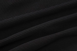 Detailed macro view of black ribbed knit fabric showing vertical texture and elasticity
