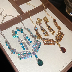 Detail of luxury necklace and earrings sets with blue and amber water drop crystals