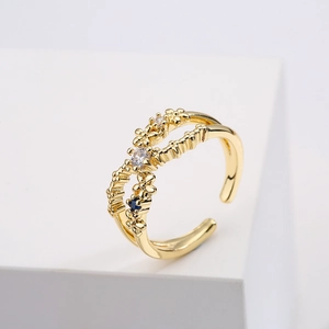 Minimalist gold plated copper open ring with zircon stones and blue gem on white block