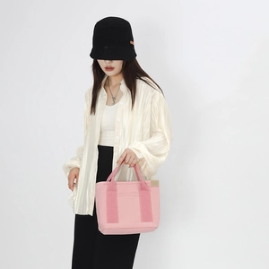 Detailed close-up of pink canvas tote bag with thick handles and beige piping details