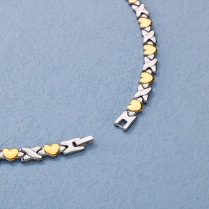 Close-up of gold and silver heart-shaped magnetic clasp links on titanium steel bracelet