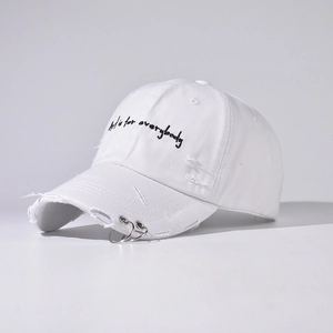 Detail of white canvas hat with Art is for everybody embroidery and metal rings