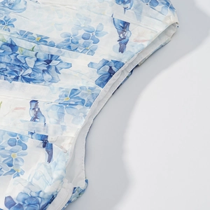 Detail of floral chiffon dress showing side invisible zipper and pleated fabric texture