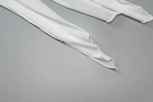 Détail de la manche en tissu mesh blanc avec coutures overlock et texture de maille