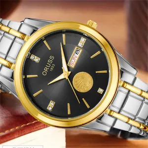 Close-up of ORUSS luxury watch face with gold sailboat relief and crystal hour markers