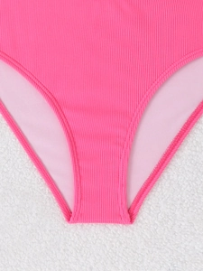 Detailed macro view of the hot pink ribbed knit fabric and stitching on bikini bottom
