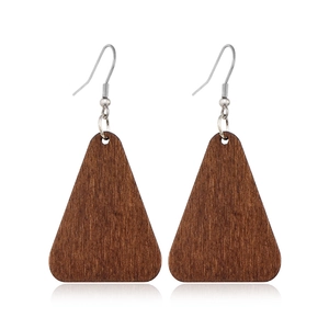 Detail view of triangular brown wood pendant earrings with silver hooks on white background
