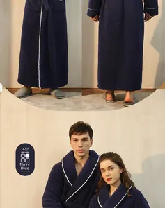 Dettaglio dell'accappatoio in pile blu scuro con profili bianchi e tasche laterali capienti