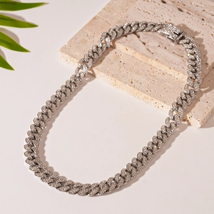 Detailed close-up of a silver iced-out cuban link necklace with a paved square clasp on stones