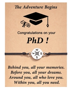 Detail of handmade black woven bracelet with silver compass charm on a PhD graduation card