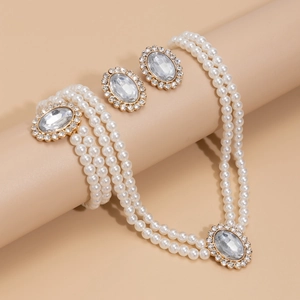 Detailed view of a 3-piece vintage pearl necklace, bracelet and earring set with crystals