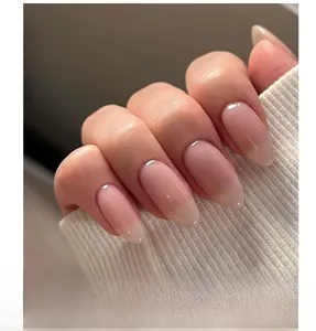 Detailed view of nude pink gradient press-on nails with 3D white bow and silver rhinestone