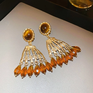 Makroansicht von Vintage Gold-Ohrringen mit bernsteinfarbenen Tropfen und Strasssteinen