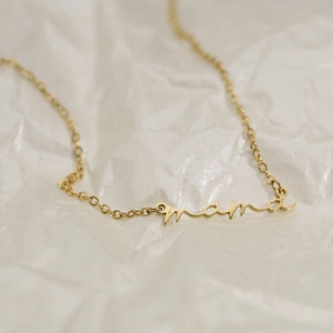 Elegant gold-plated stainless steel Mama letter pendant necklace on a textured white surface