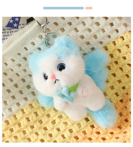Close-up of plush blue angel cat keychain with vibrant eyes and soft faux fur texture