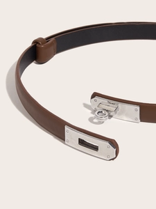 Close-up of brown leather skinny belt with silver buckle and detailed stitching