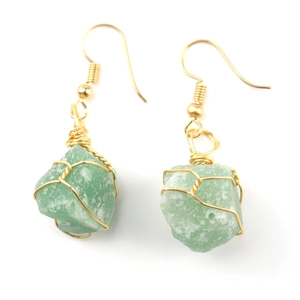 Detail of handmade gold wire-wrapped natural green stone earrings in a bohemian style