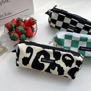 Detalle de estuches de lona con estampados de leopardo y cuadros en un entorno de estilo