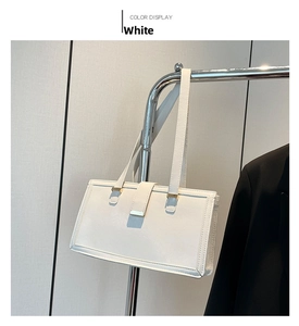 Close-up of a white minimalist rectangular shoulder bag with golden hardware details