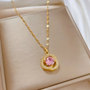 Gold stainless steel necklace with pink gemstone and zircon pendant on white silk